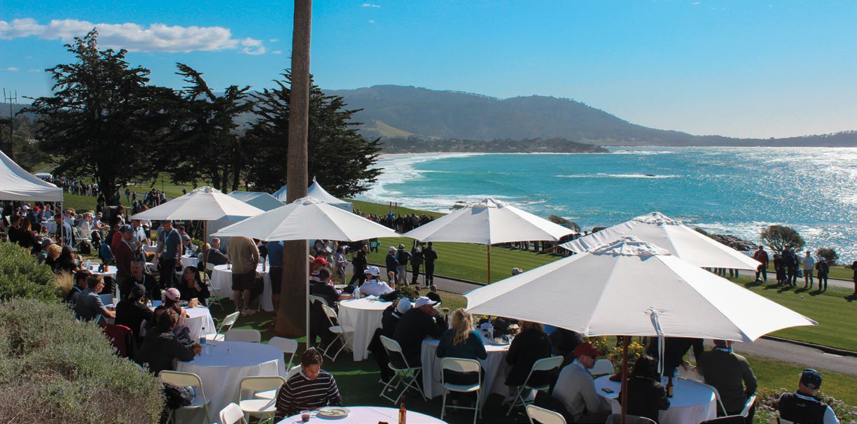 Guests dining on the private ISM estate terrace overlooking Pebble Beach and the Pacific Ocean