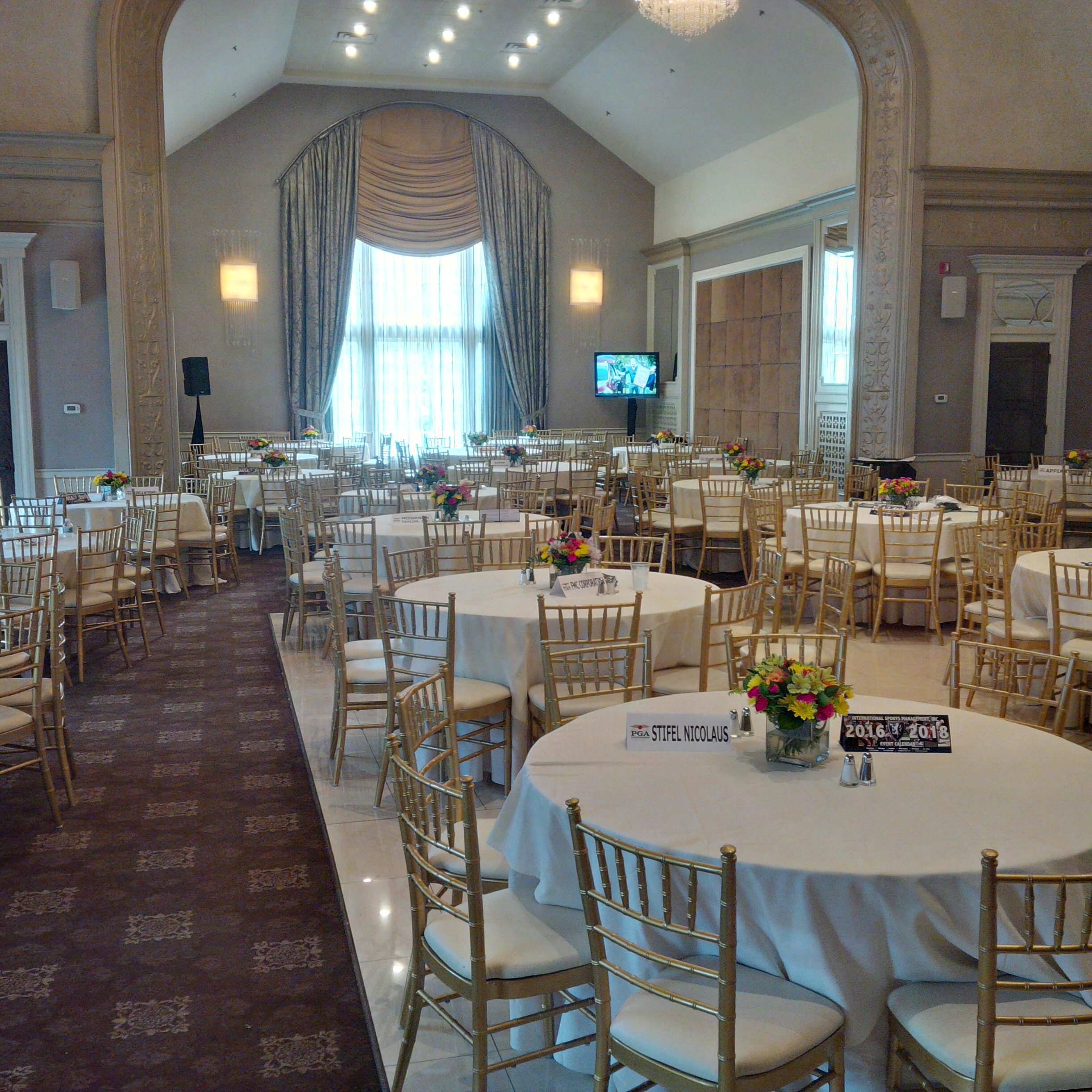 ISM hospitality ballroom with dining tables and televisions, supplied by Terry