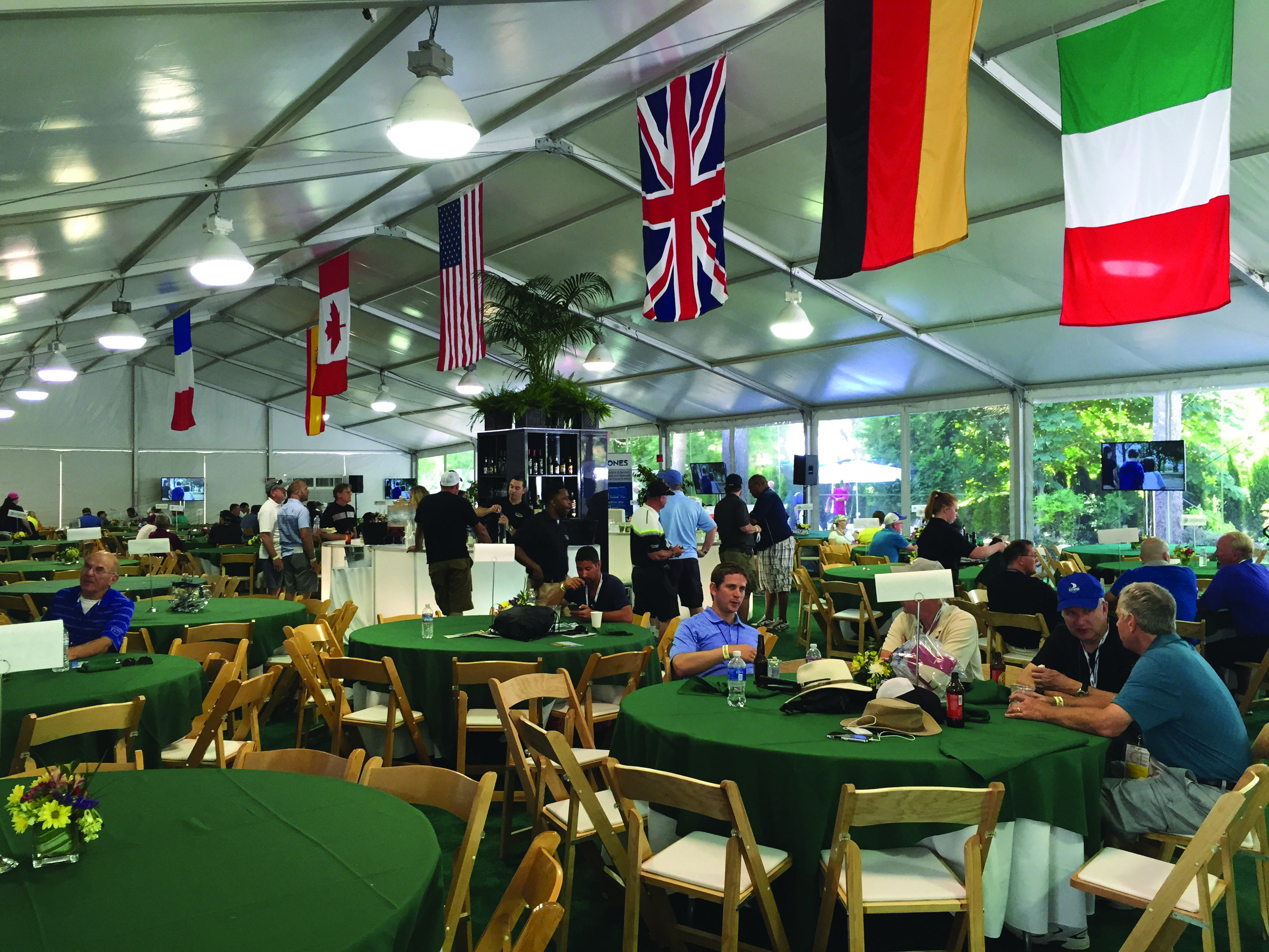 Guests and dining tables inside an ISM hospitality pavilion at a previous event