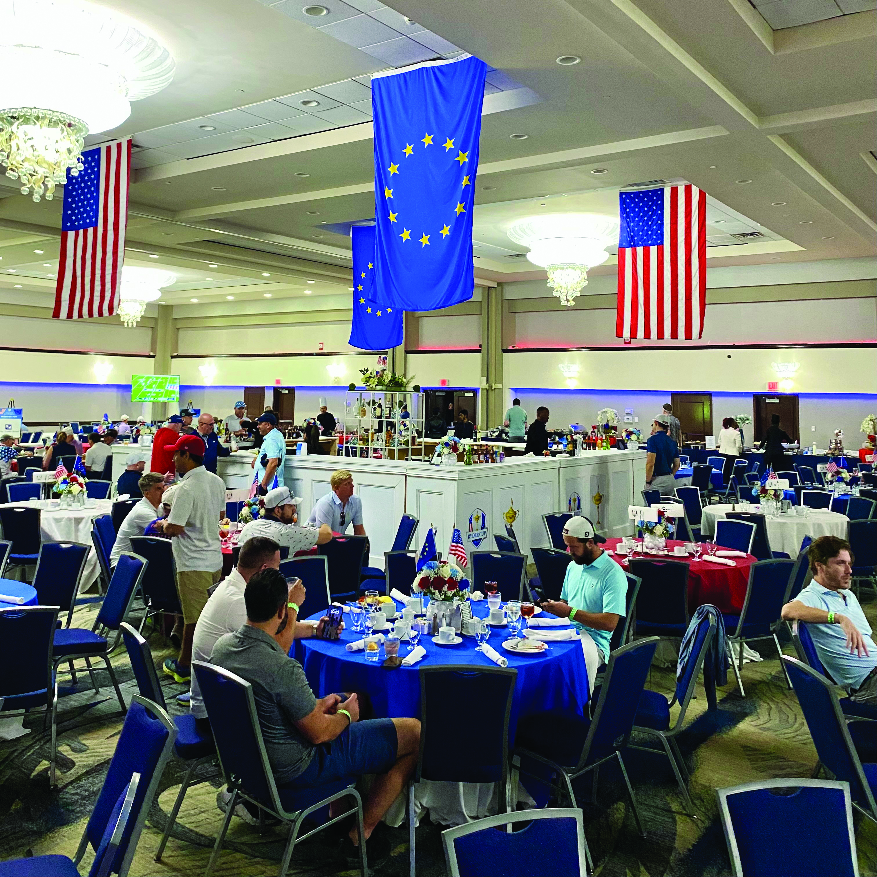 A previous ISM Ryder Cup hospitality room with USA and Europe flags above the dining tables
