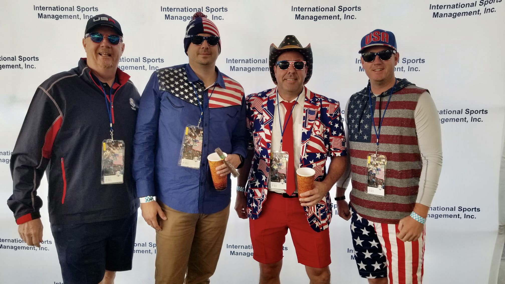 Four Team USA fans in front of an ISM backdrop at a previous Ryder Cup
