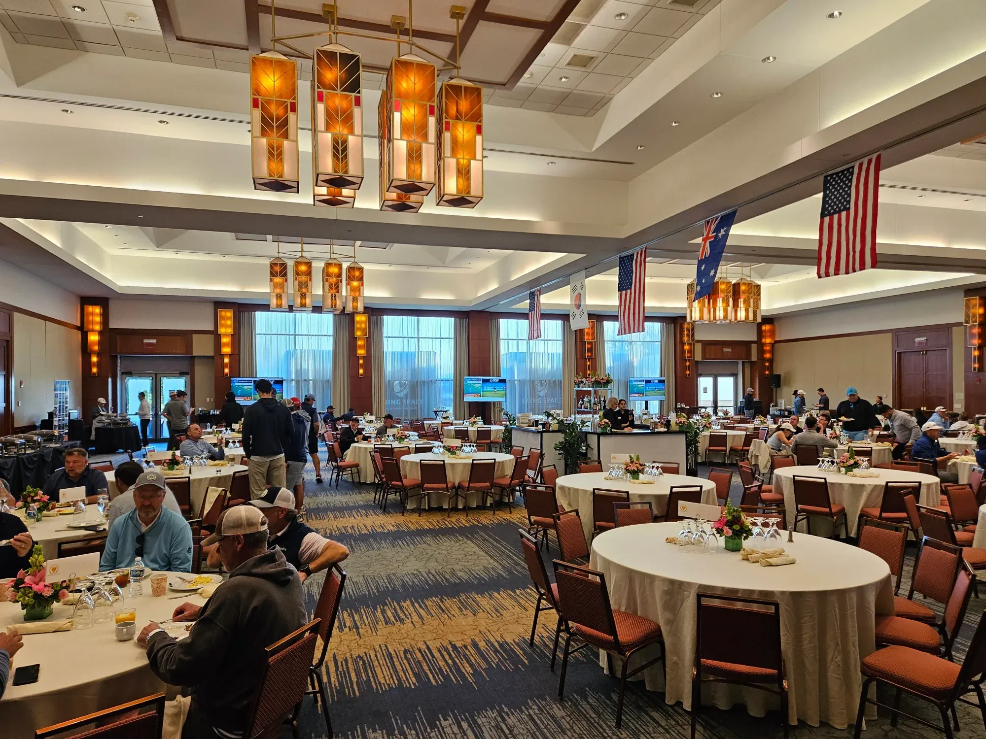 A ballroom with guests seated at or moving between tables.