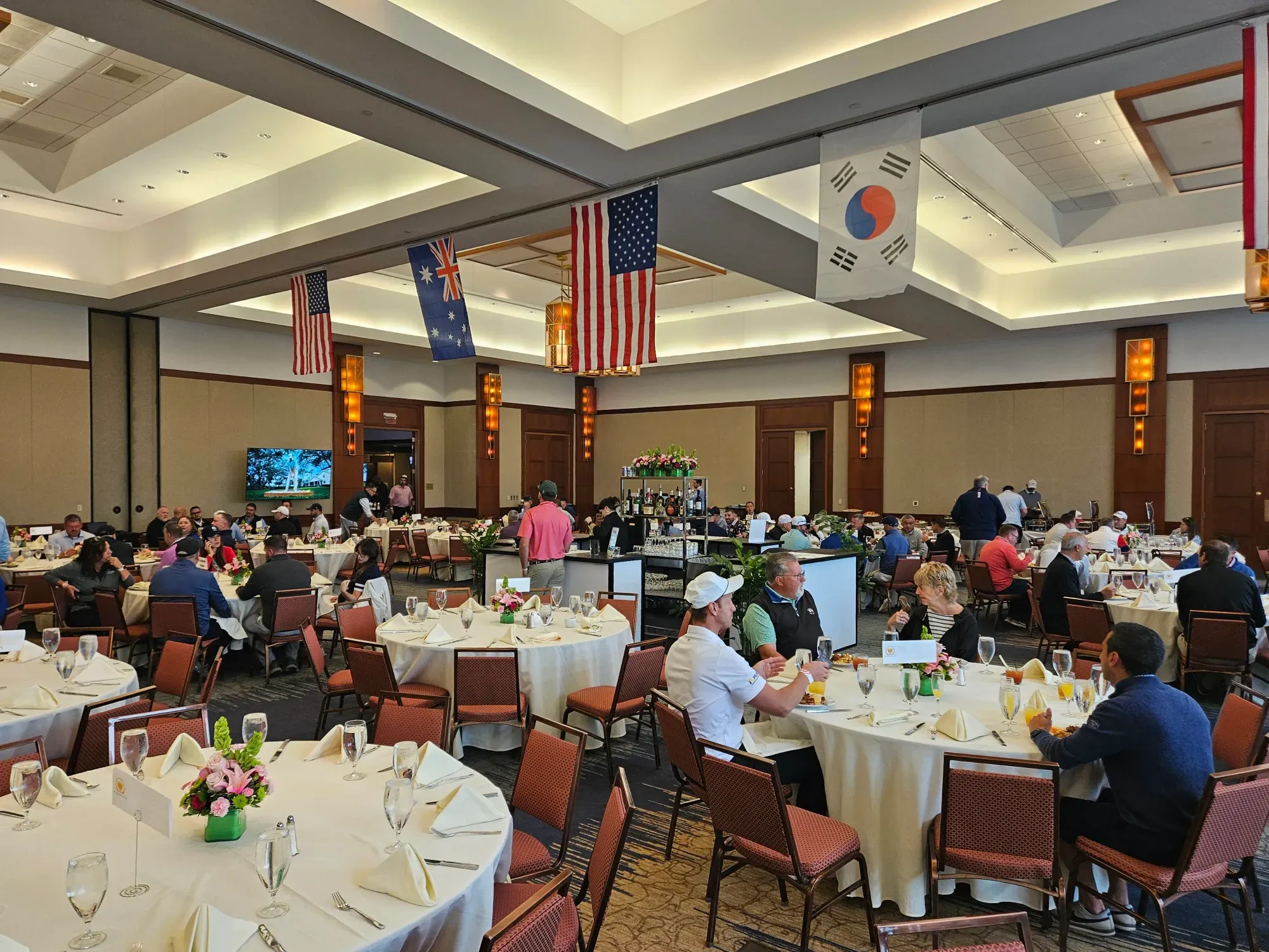 A ballroom with guests seated at or moving between tables.