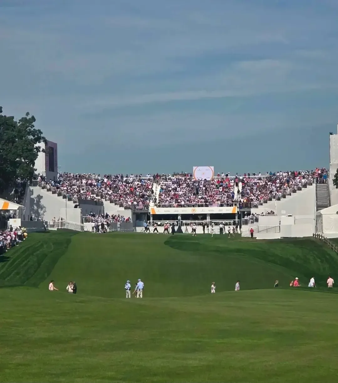 Golfers and spectators at the first tee of the 2026 Presidents Cup at Medinah Country Club.