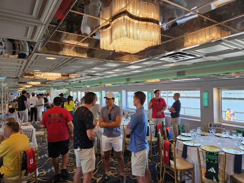Guests gathering beneath a chandelier in a reception venue